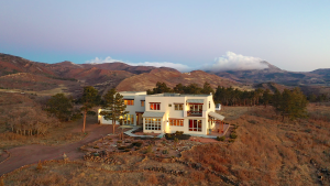 house with mountains and clouds in background
